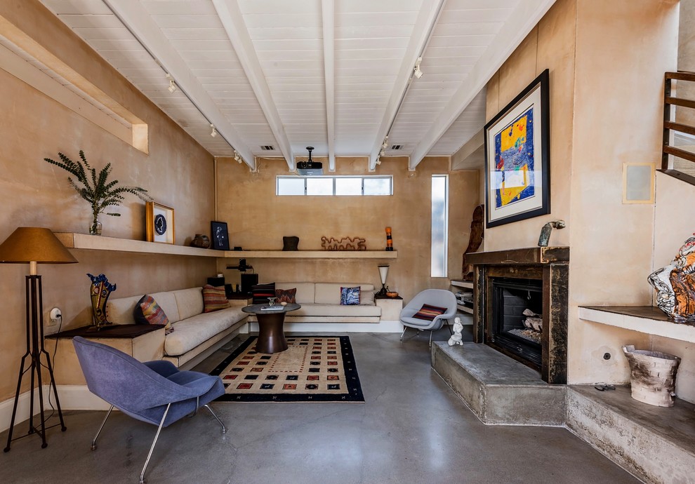 Bild på ett funkis vardagsrum, med bruna väggar, betonggolv, en standard öppen spis och grått golv