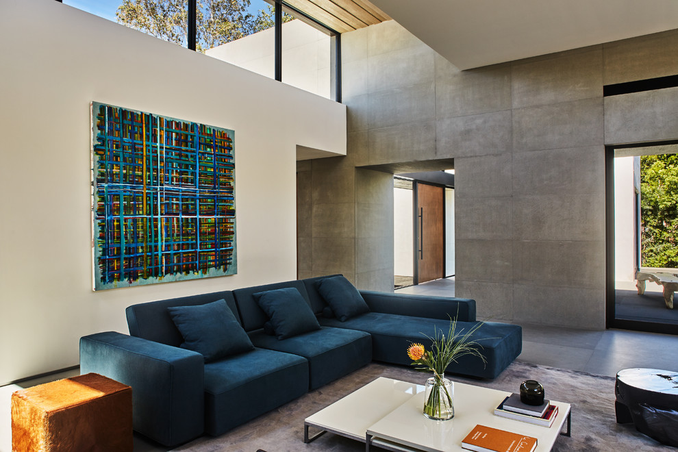 Großes, Offenes Modernes Wohnzimmer mit Kamin, Kaminumrandung aus Stein, Multimediawand, grauer Wandfarbe und grauem Boden in Los Angeles