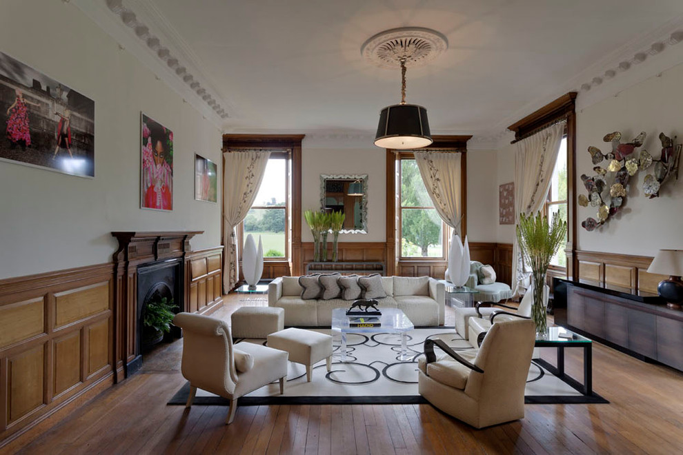 Ejemplo de salón para visitas actual sin televisor con paredes blancas, suelo de madera en tonos medios y todas las chimeneas