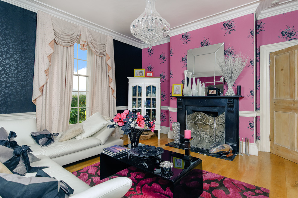 Idee per un soggiorno minimal chiuso con pareti rosa, pavimento in legno massello medio e camino classico