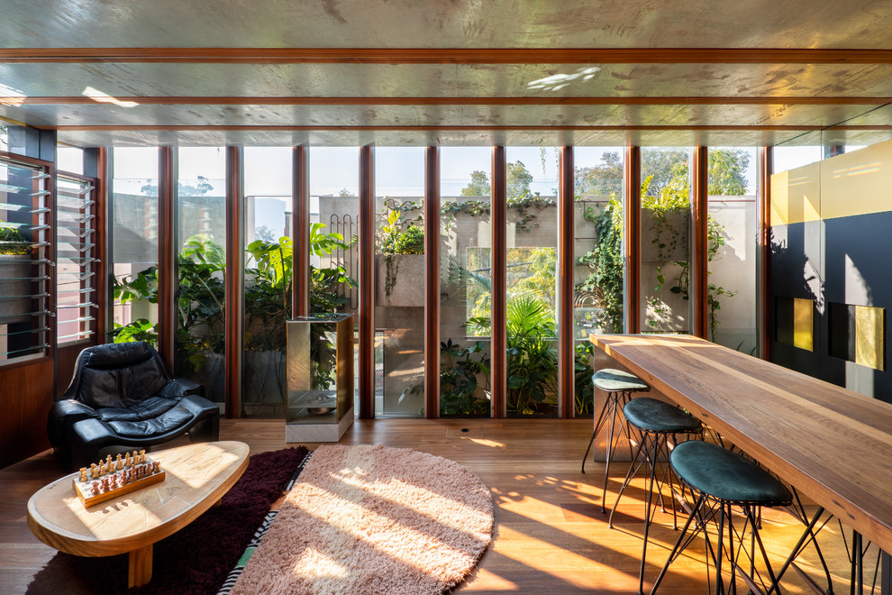 Immagine di un soggiorno design con pavimento in legno massello medio e pavimento marrone