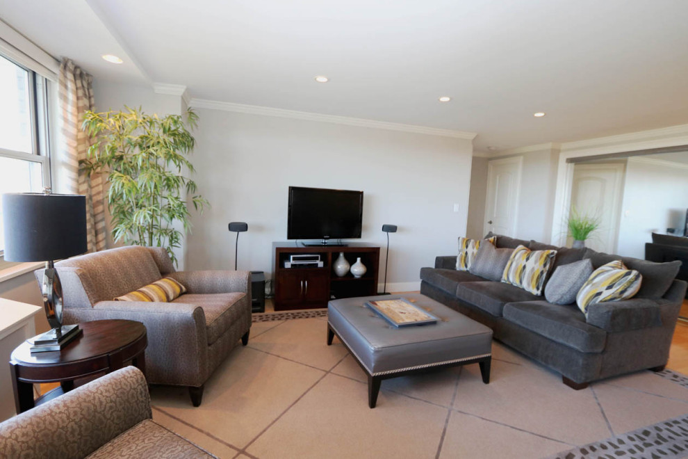 Foto de salón contemporáneo grande con paredes beige, suelo de madera clara y televisor independiente