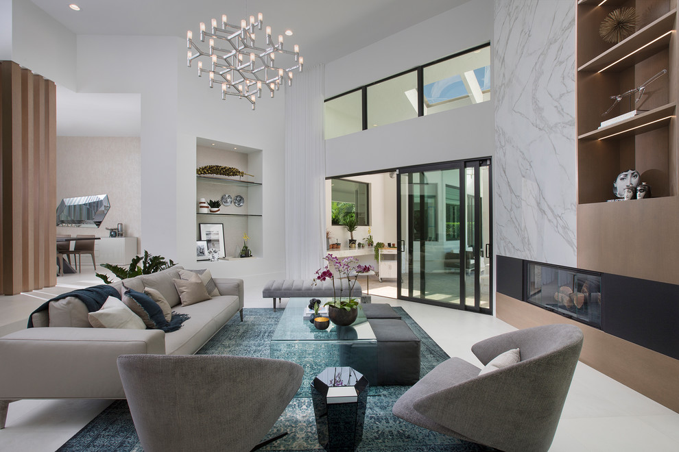 Offenes Modernes Wohnzimmer mit weißer Wandfarbe, Gaskamin und Kaminumrandung aus Stein in Miami