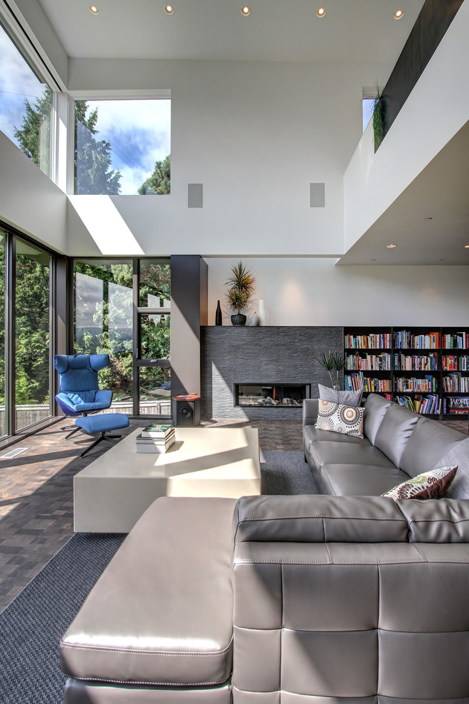 Offenes Modernes Wohnzimmer mit weißer Wandfarbe, dunklem Holzboden, Gaskamin und Kaminumrandung aus Stein in Seattle