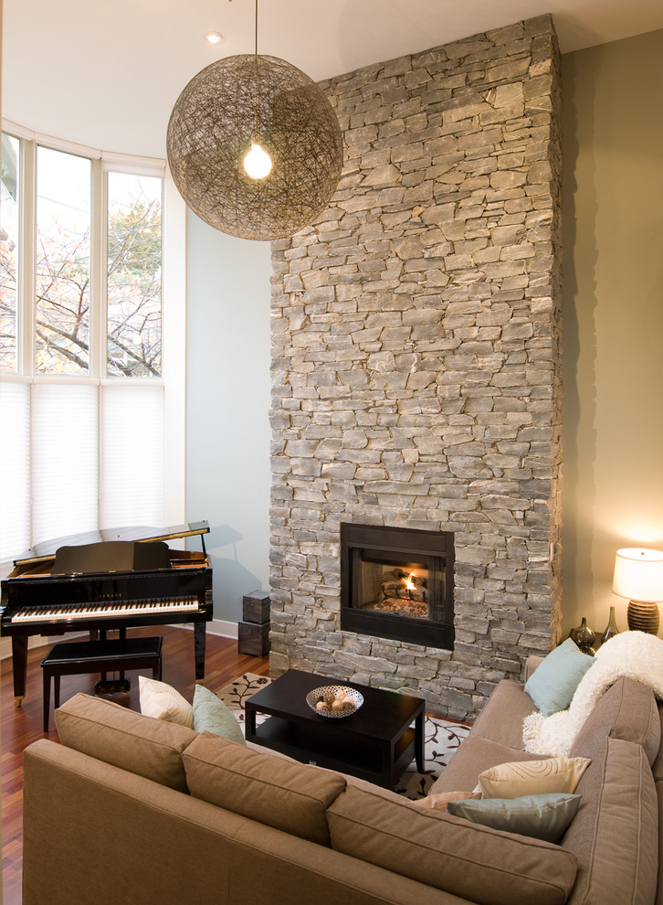 Aménagement d'un salon contemporain avec un manteau de cheminée en pierre.