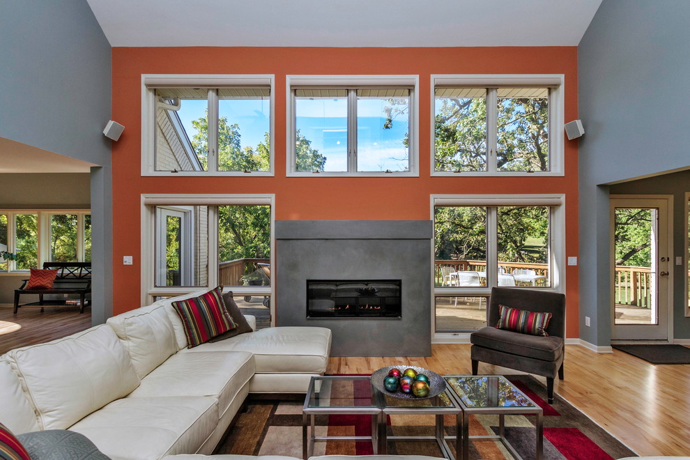 Modernes Wohnzimmer mit Kaminumrandung aus Beton, grauer Wandfarbe und beigem Boden in Cedar Rapids