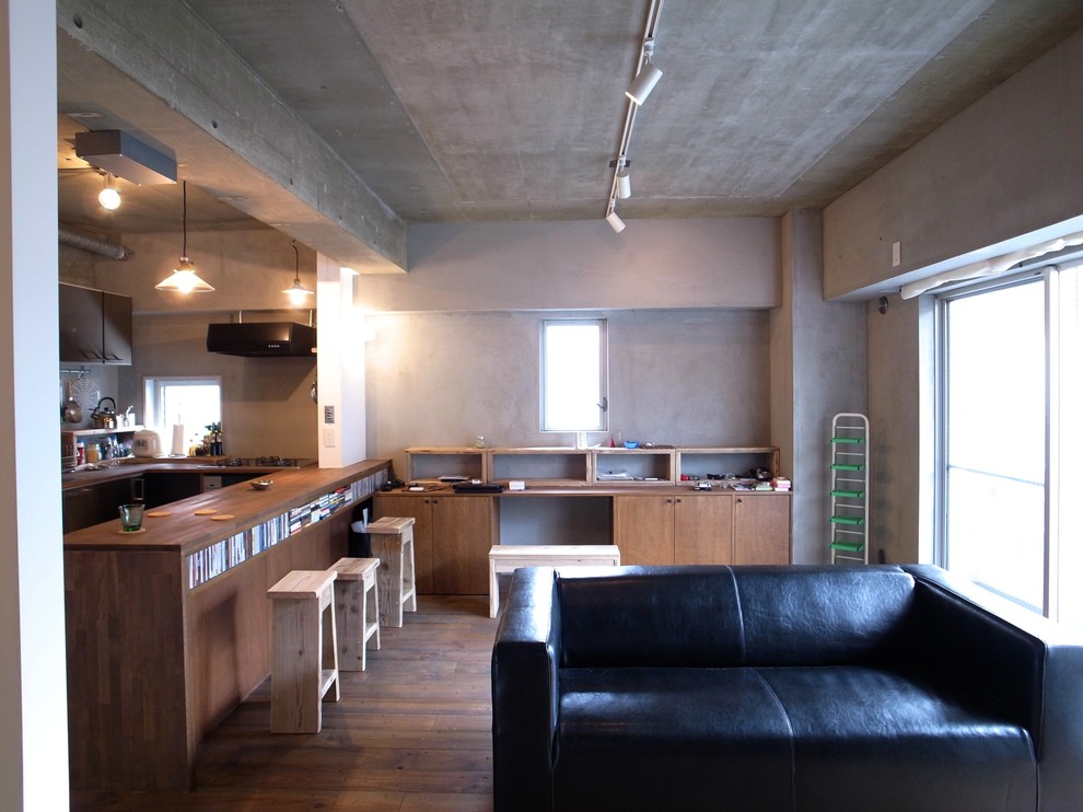 Cette image montre un salon design ouvert avec un mur gris et parquet foncé.