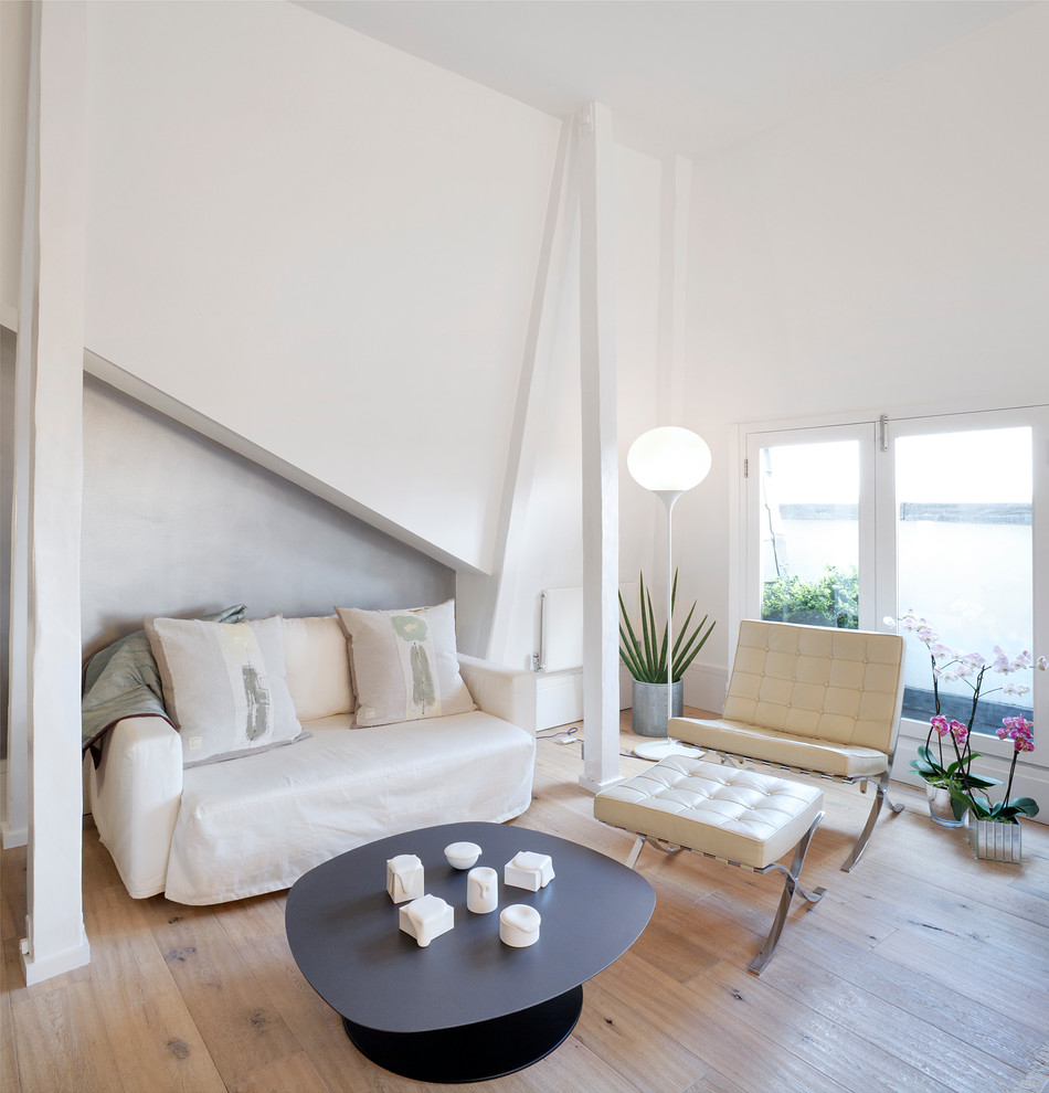 Diseño de salón para visitas escandinavo sin chimenea y televisor con paredes blancas y suelo de madera clara
