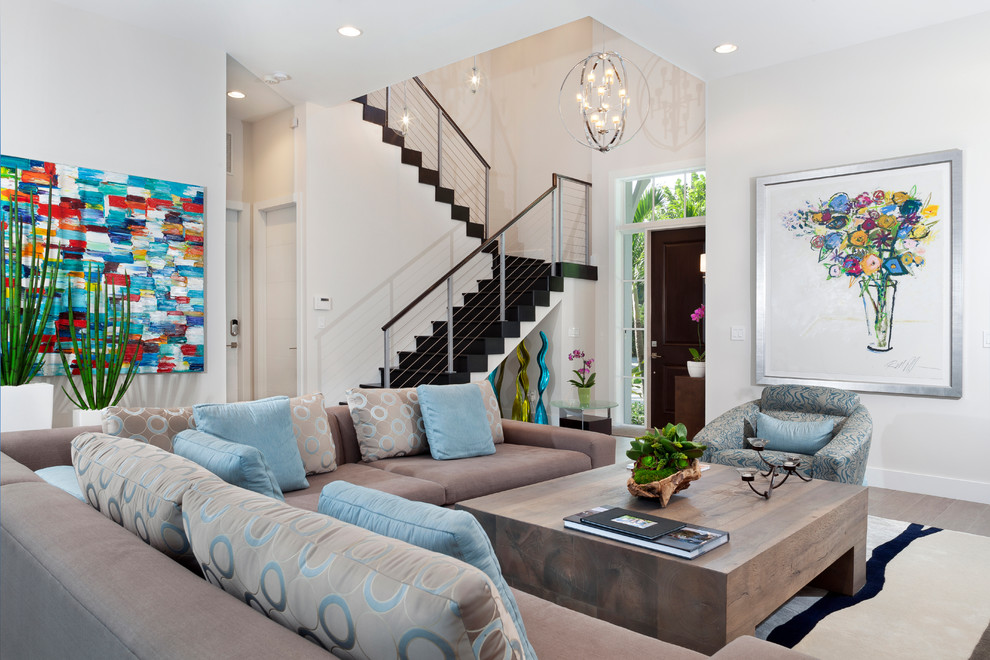 Cette image montre un salon design ouvert avec un mur blanc et un escalier.