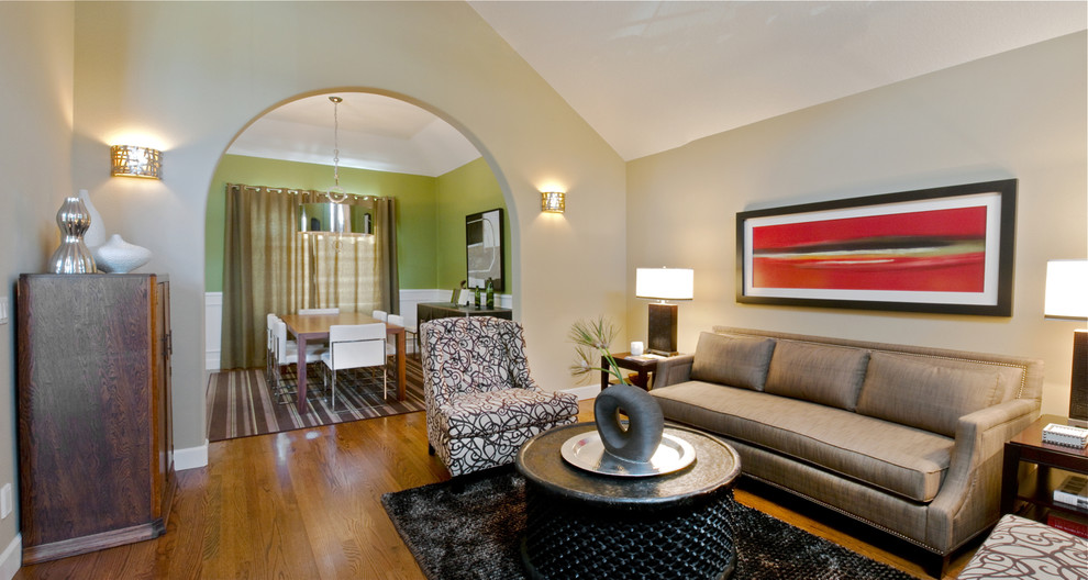 Modernes Wohnzimmer mit beiger Wandfarbe, braunem Holzboden und Rundbogen in Sonstige