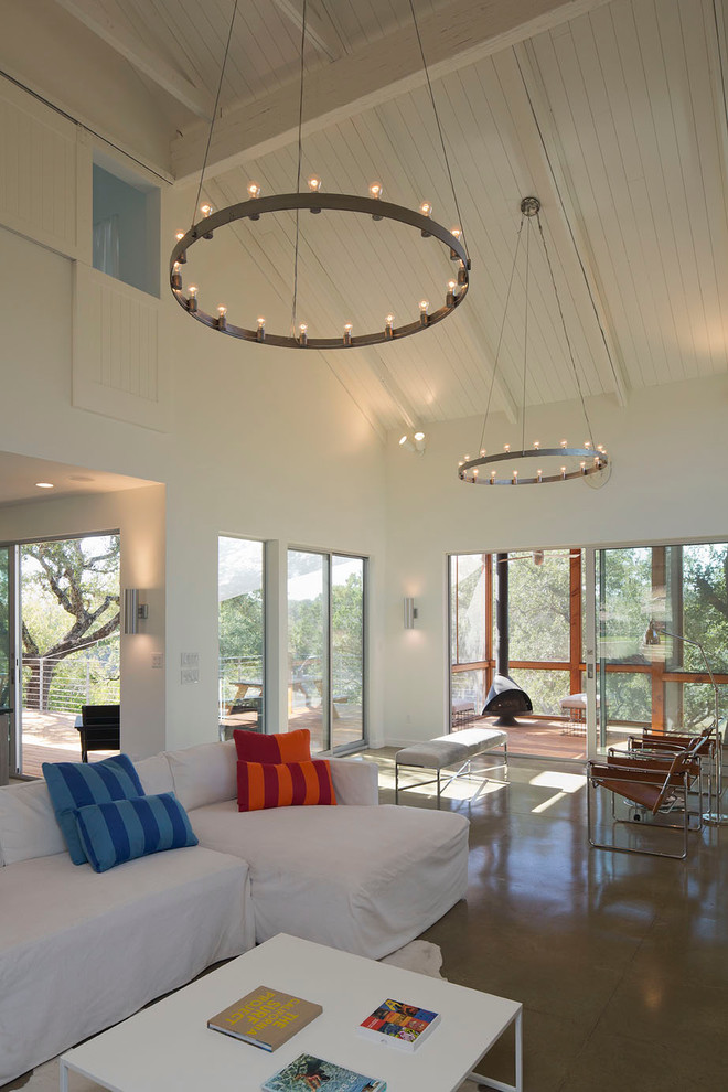 Inspiration for a contemporary living room in Austin with white walls and concrete flooring.