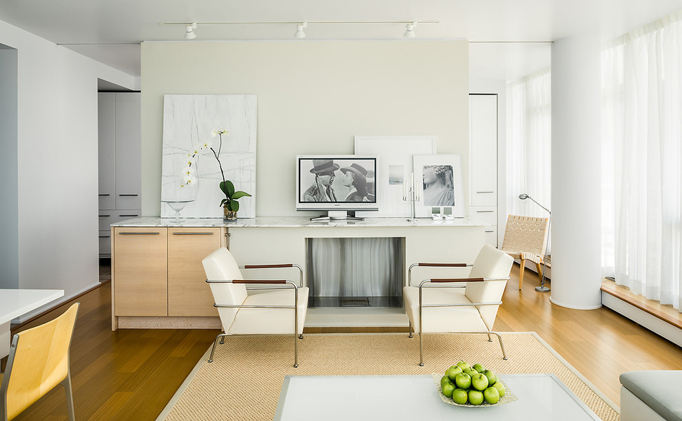 Стильный дизайн: гостиная комната в современном стиле с белыми стенами и отдельно стоящим телевизором - последний тренд