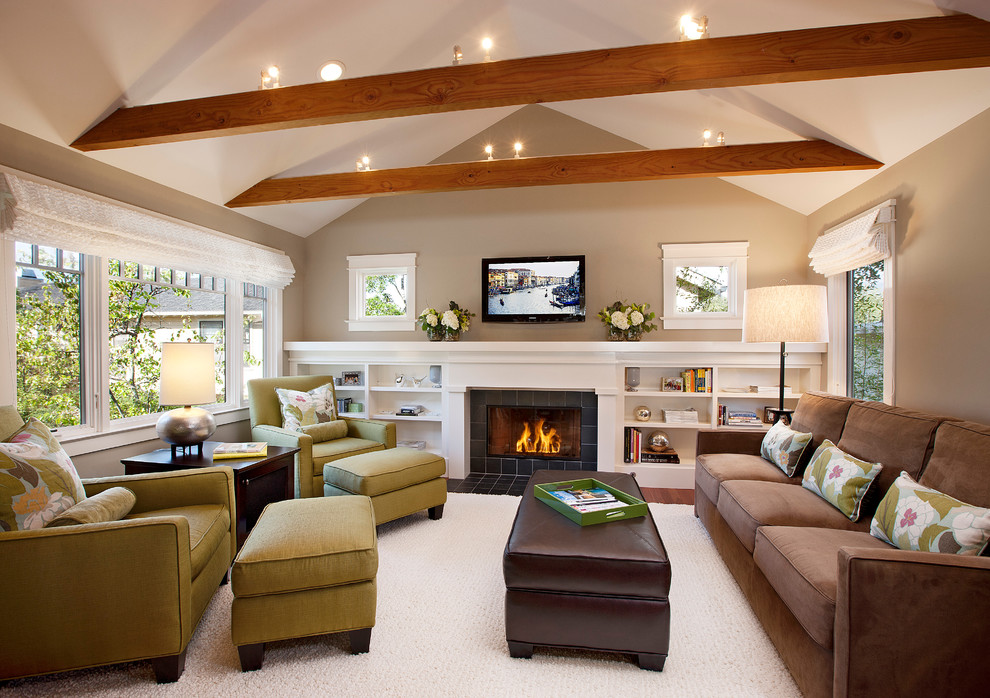 На фото: гостиная комната в современном стиле с фасадом камина из плитки, коричневым диваном и ковром на полу с
