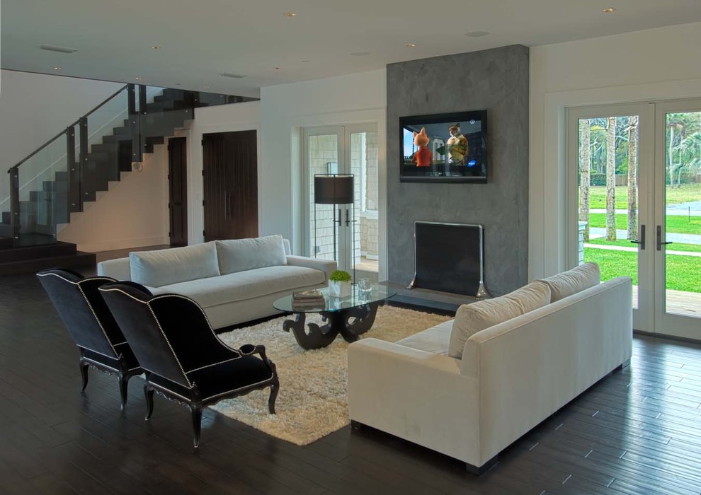 Источник вдохновения для домашнего уюта: гостиная комната в современном стиле с стандартным камином, телевизором на стене и фасадом камина из штукатурки