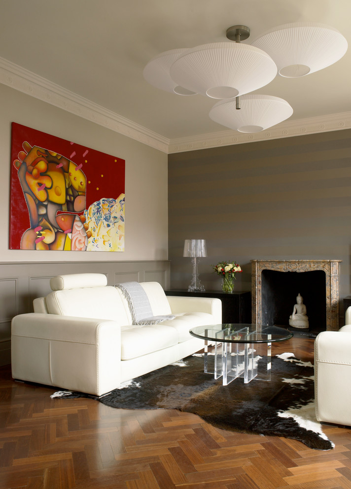 Esempio di un soggiorno minimal con pareti grigie e camino classico