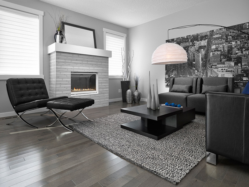 This is an example of a medium sized contemporary formal open plan living room in Montreal with grey walls, a standard fireplace, no tv, grey floors, light hardwood flooring and a brick fireplace surround.