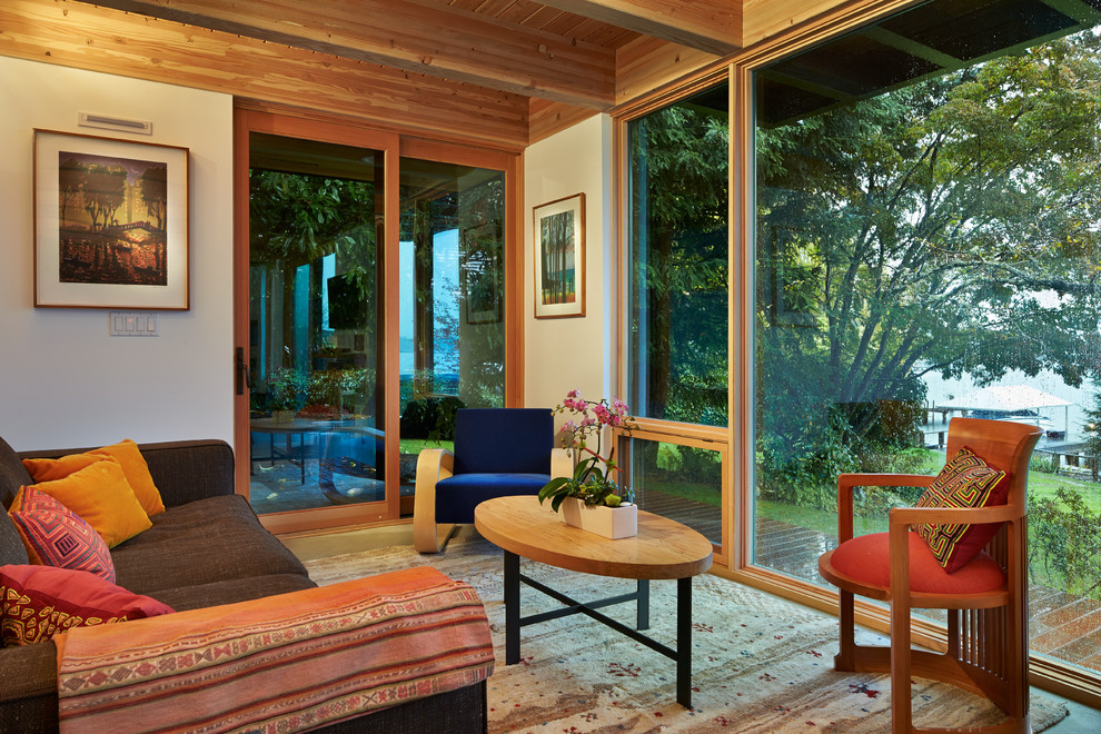 Стильный дизайн: гостиная комната в современном стиле с бетонным полом и коричневым диваном - последний тренд
