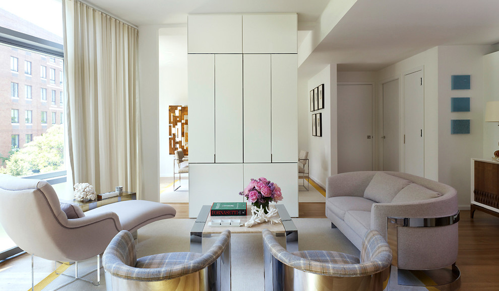 Modelo de salón para visitas abierto contemporáneo de tamaño medio con paredes blancas, suelo de madera clara, televisor retractable y alfombra
