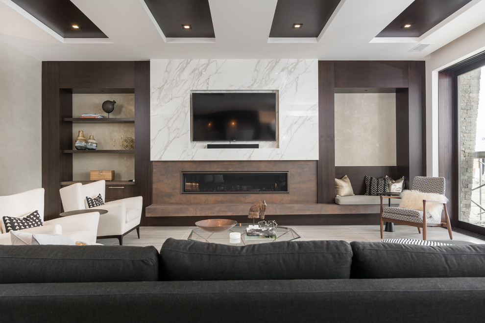 バンクーバーにあるコンテンポラリースタイルのおしゃれな独立型リビング (ベージュの壁、横長型暖炉、金属の暖炉まわり、壁掛け型テレビ、ベージュの床) の写真