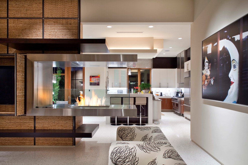 Immagine di un soggiorno design con camino bifacciale e TV nascosta