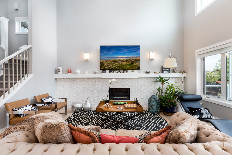 Immagine di un soggiorno contemporaneo aperto con pareti grigie, parquet chiaro, camino classico, TV a parete e pavimento beige