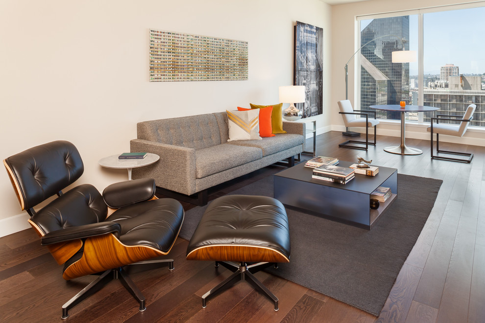 Immagine di un soggiorno design con pareti beige e parquet scuro