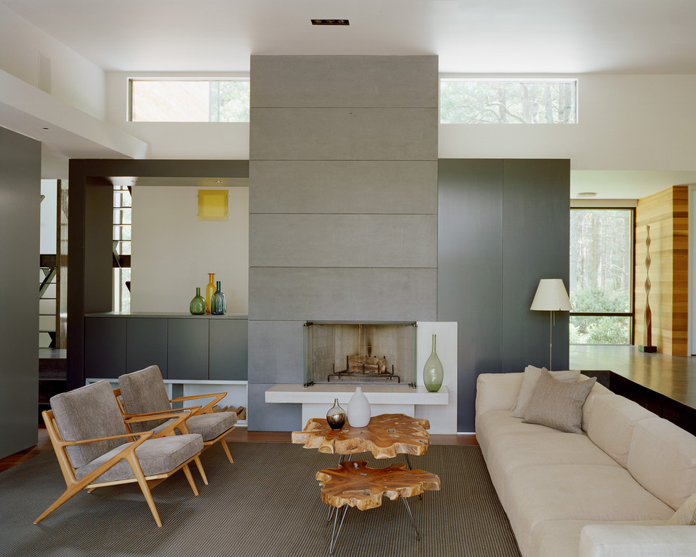 Contemporary living room in New York with a concrete fireplace surround and feature lighting.