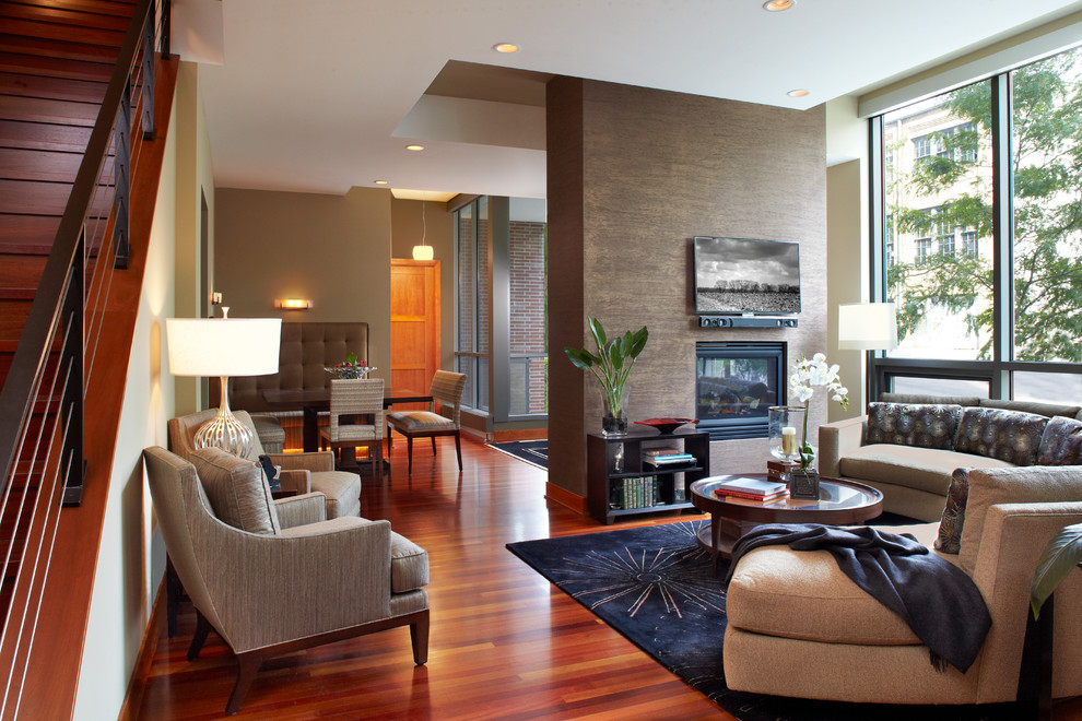 На фото: открытая гостиная комната в современном стиле с серыми стенами и телевизором на стене с