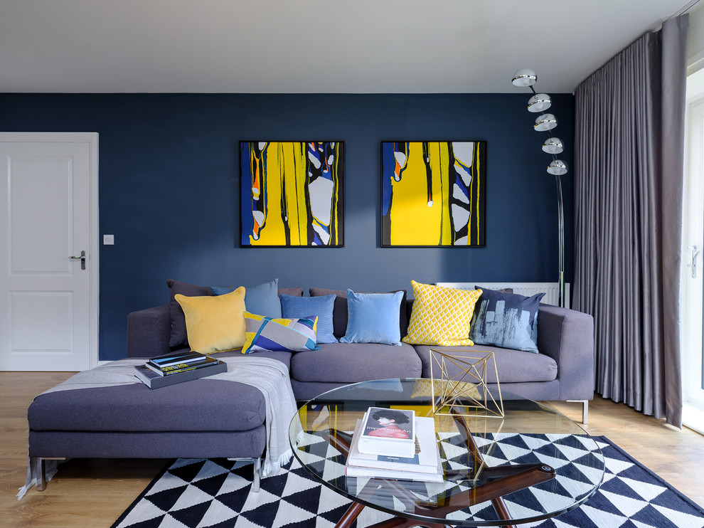 На фото: изолированная гостиная комната среднего размера в современном стиле с синими стенами, светлым паркетным полом и коричневым полом без камина с