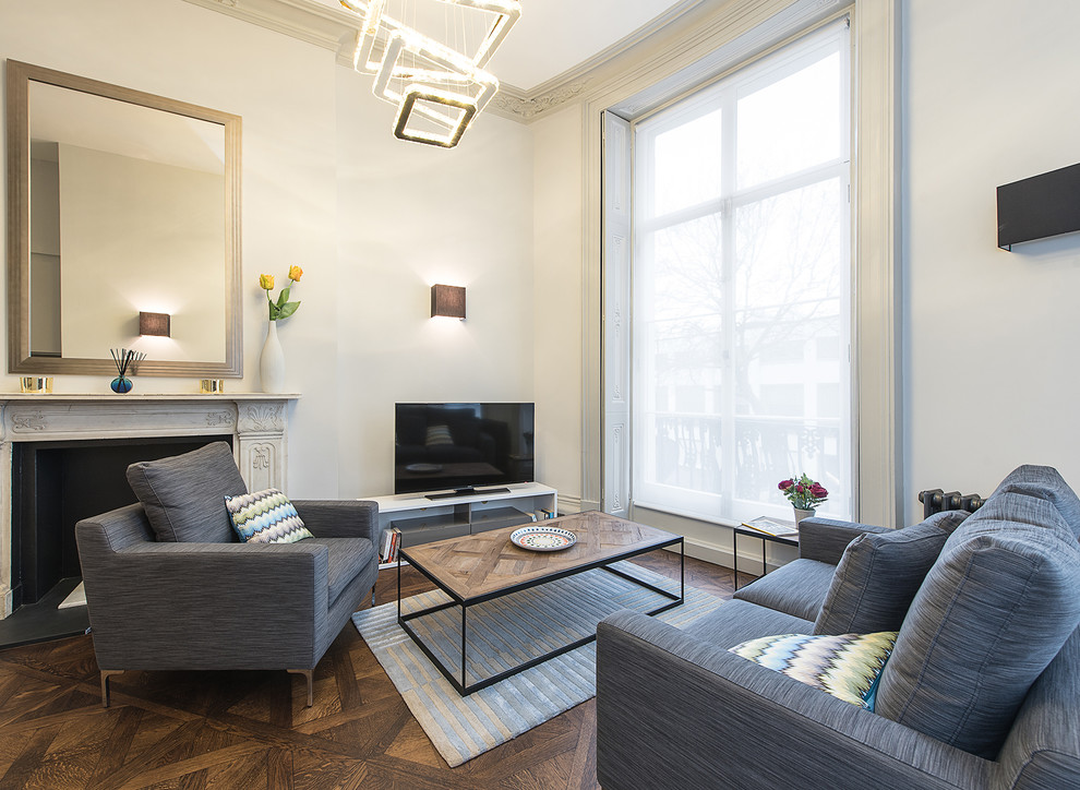 Modernes Wohnzimmer mit weißer Wandfarbe, dunklem Holzboden, Kamin und freistehendem TV in London