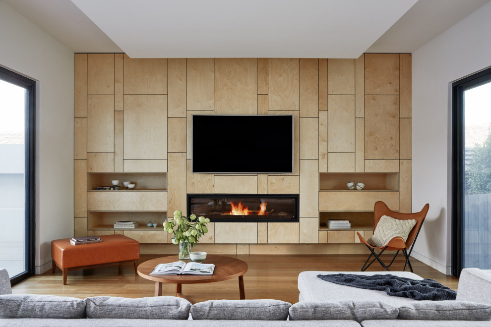 Aménagement d'un grand salon contemporain ouvert avec un mur blanc, une cheminée ribbon, un manteau de cheminée en carrelage, un téléviseur fixé au mur et un sol marron.