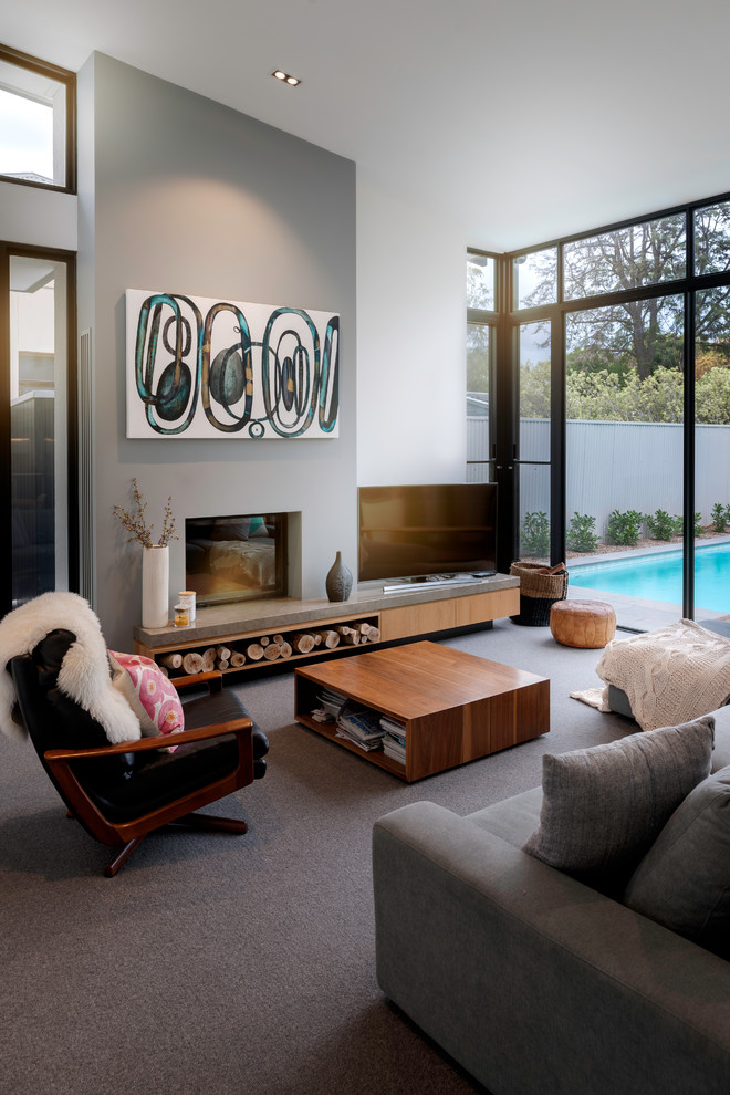 Modernes Wohnzimmer mit weißer Wandfarbe, Teppichboden, Kamin, freistehendem TV und grauem Boden in Adelaide