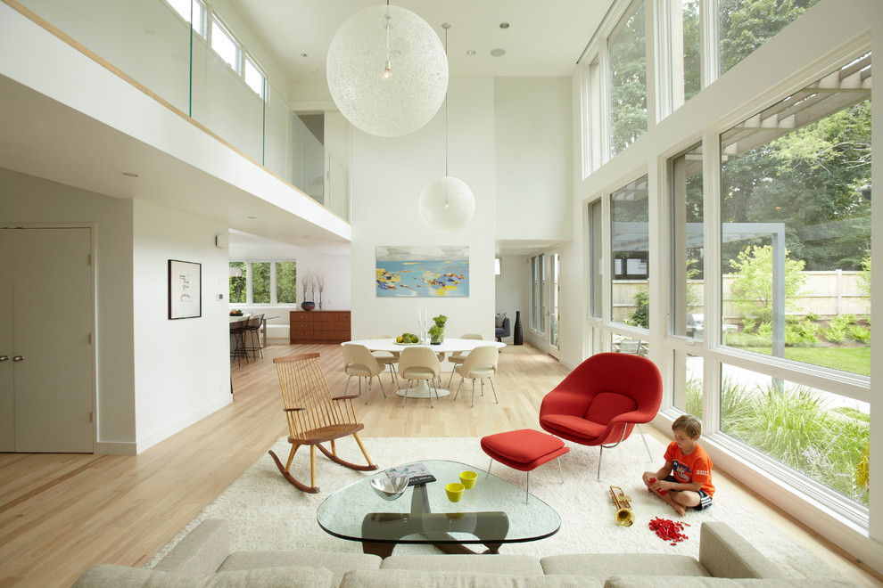Imagen de salón abierto contemporáneo con paredes blancas y suelo de madera clara