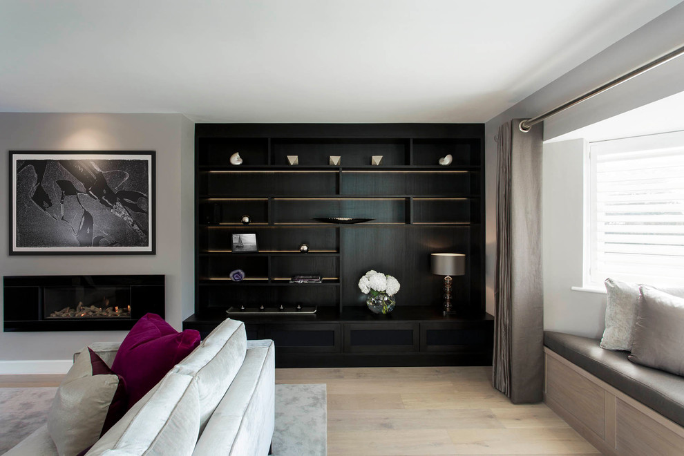 Diseño de salón para visitas cerrado actual de tamaño medio sin televisor con paredes grises, suelo de madera clara y chimenea lineal