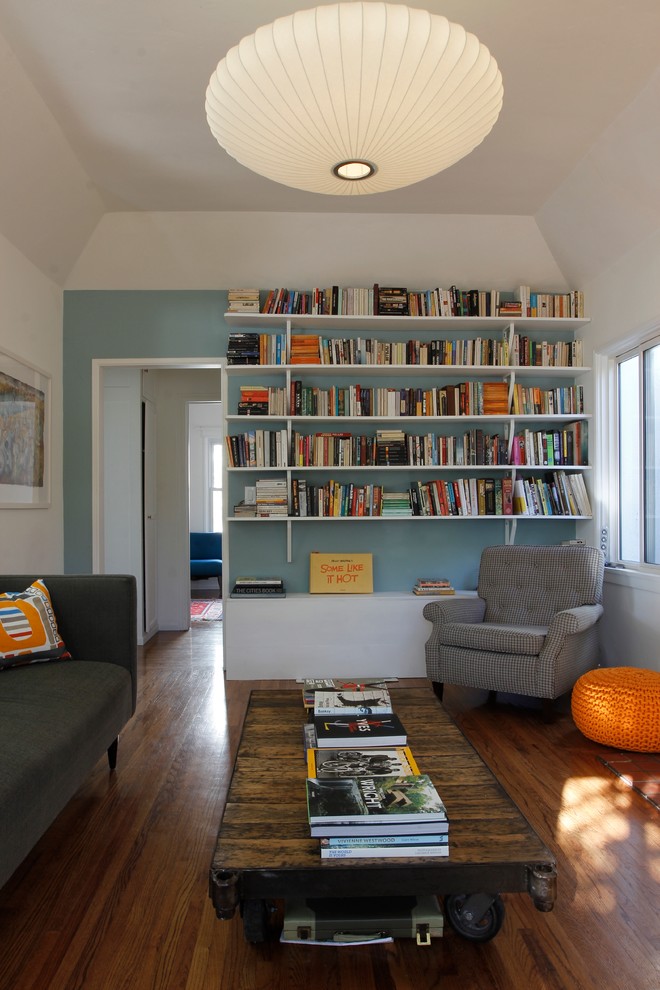 Idee per un soggiorno contemporaneo chiuso con libreria, pareti blu e parquet scuro