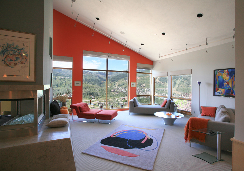 На фото: огромная гостиная комната в современном стиле с красными стенами и двусторонним камином