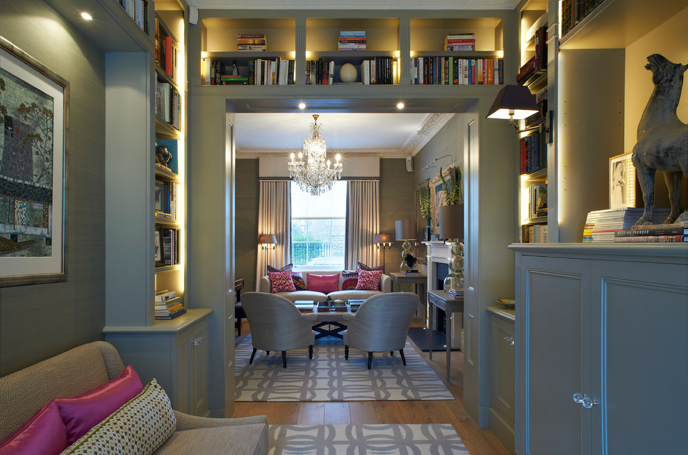 Стильный дизайн: гостиная комната в современном стиле с с книжными шкафами и полками, серыми стенами, паркетным полом среднего тона, стандартным камином и фасадом камина из камня без телевизора - последний тренд