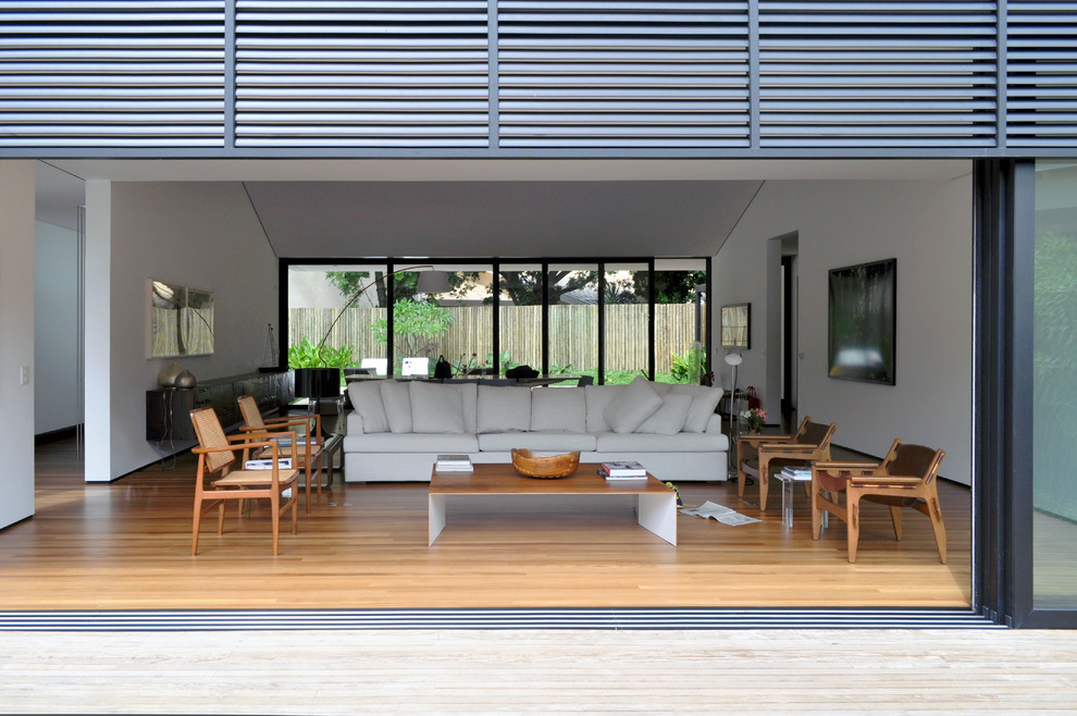 Immagine di un soggiorno contemporaneo con sala formale, pareti bianche e parquet chiaro