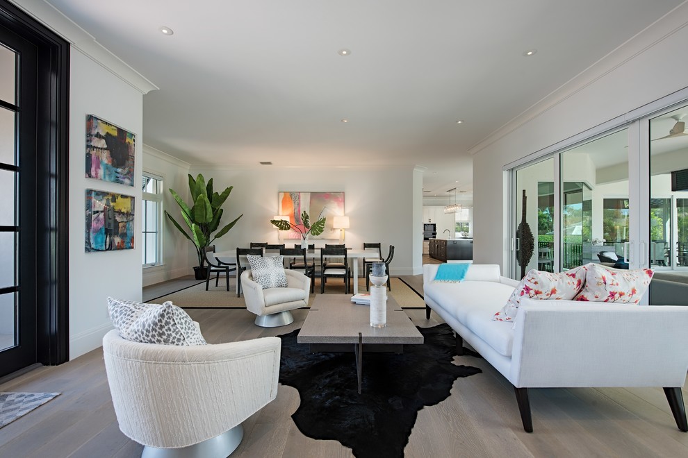 Modernes Wohnzimmer mit weißer Wandfarbe, braunem Holzboden und grauem Boden in Tampa