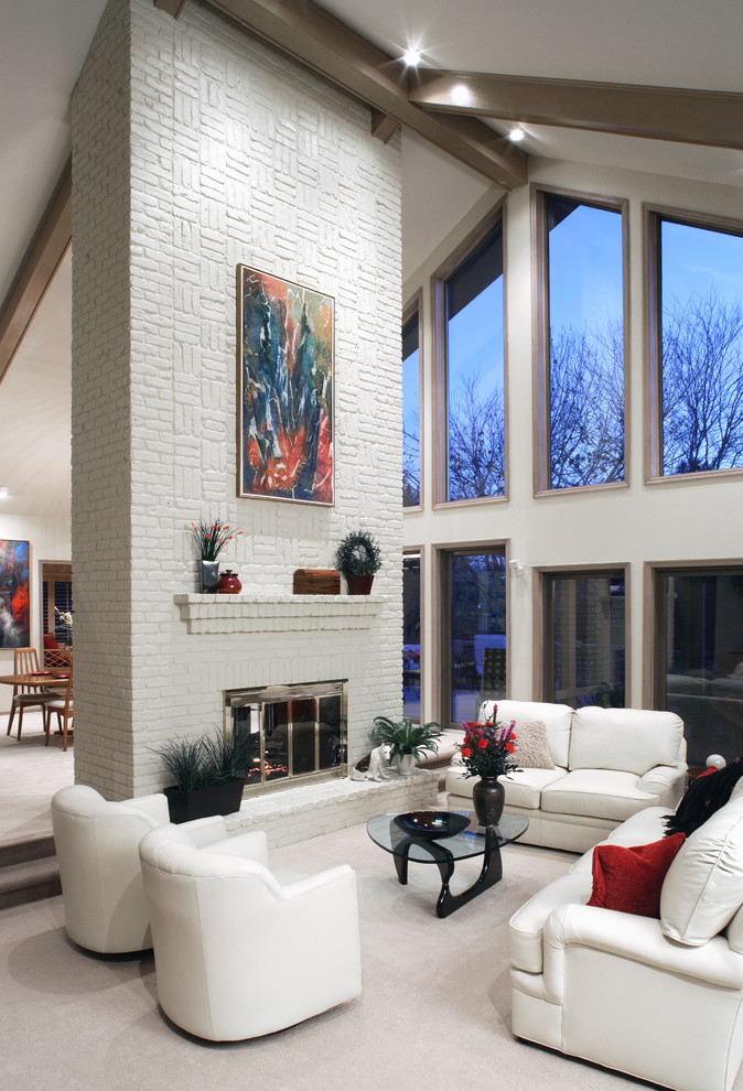 Design ideas for a medium sized contemporary formal open plan living room in Omaha with white walls, carpet, a standard fireplace, a brick fireplace surround, no tv and white floors.
