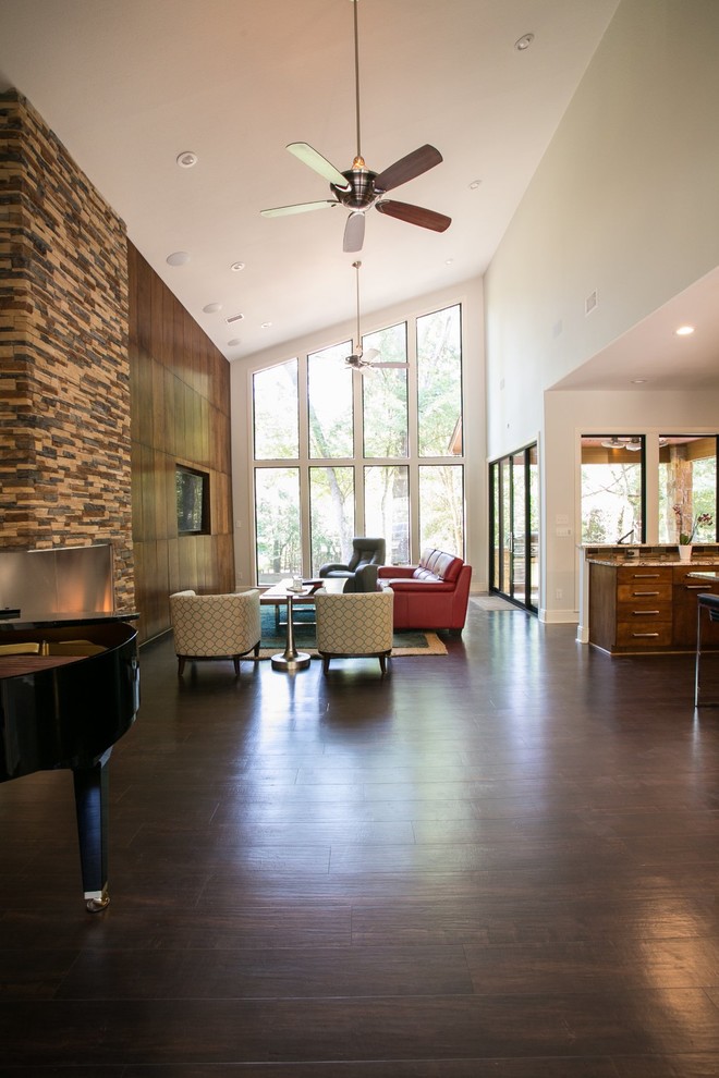This is an example of a large contemporary open plan living room in Austin with a music area, grey walls, vinyl flooring, a corner fireplace, a stone fireplace surround and a built-in media unit.