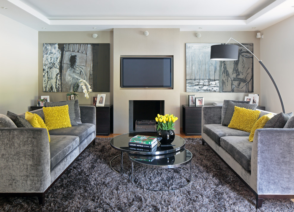 Cette photo montre un salon tendance avec un mur beige et un téléviseur fixé au mur.
