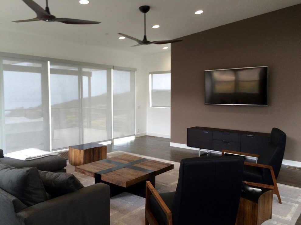 Idéer för ett mellanstort modernt separat vardagsrum, med bruna väggar, mörkt trägolv och en väggmonterad TV