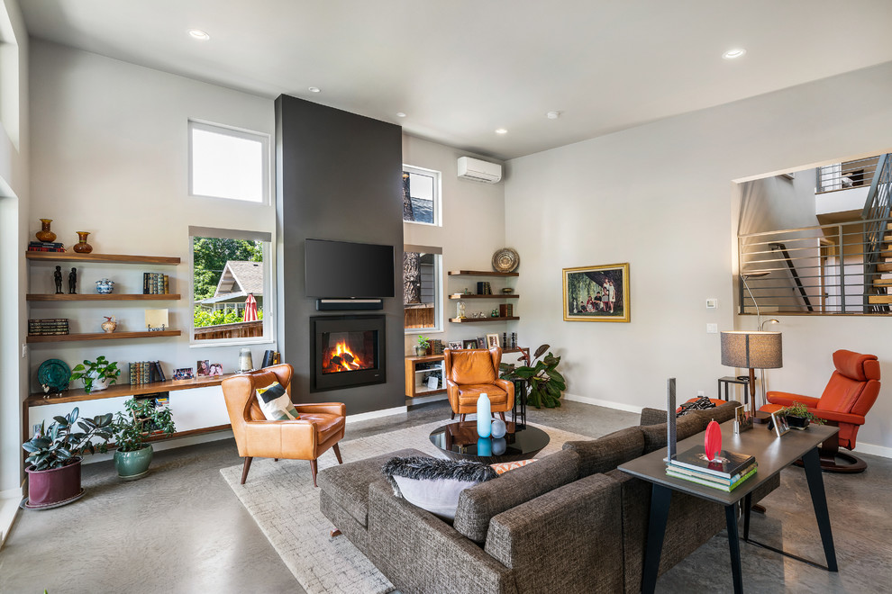 Contemporary enclosed living room in Other with grey walls, concrete flooring, a standard fireplace, a wall mounted tv and grey floors.