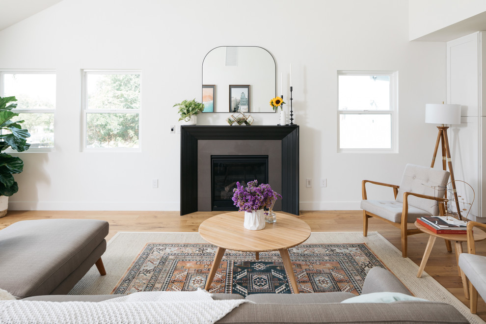 Inspiration for a transitional open concept light wood floor living room remodel in Los Angeles with white walls, a standard fireplace and no tv