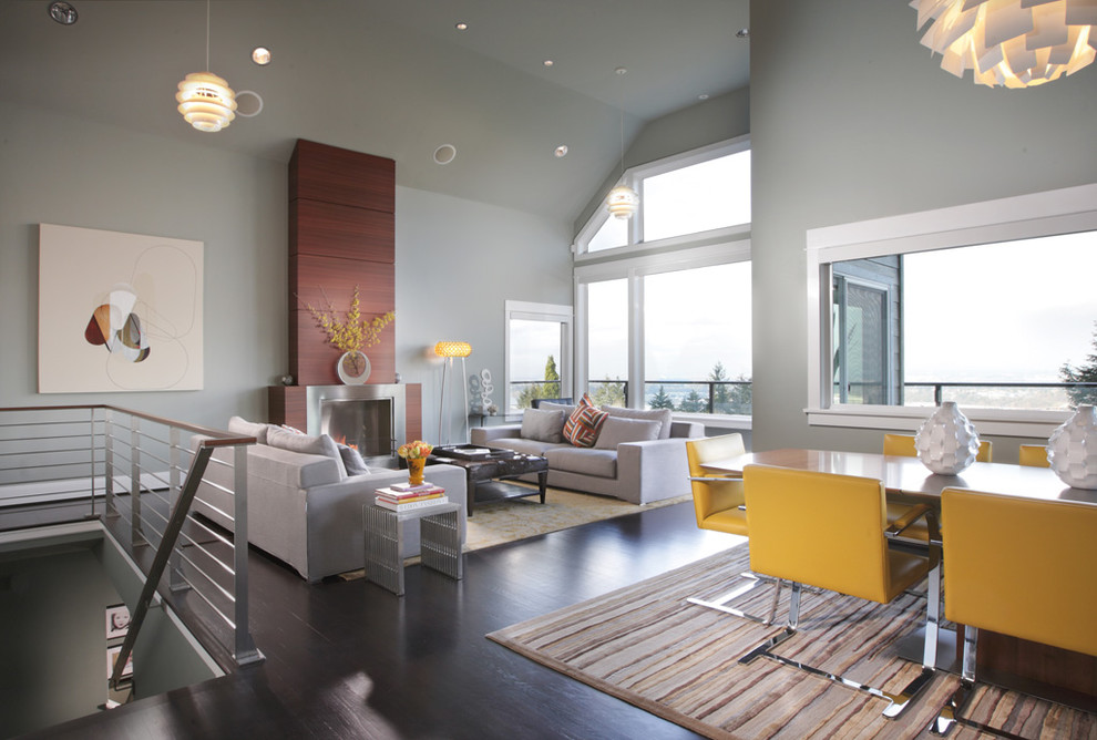 Idee per un soggiorno minimal con pareti grigie, camino classico e pavimento marrone