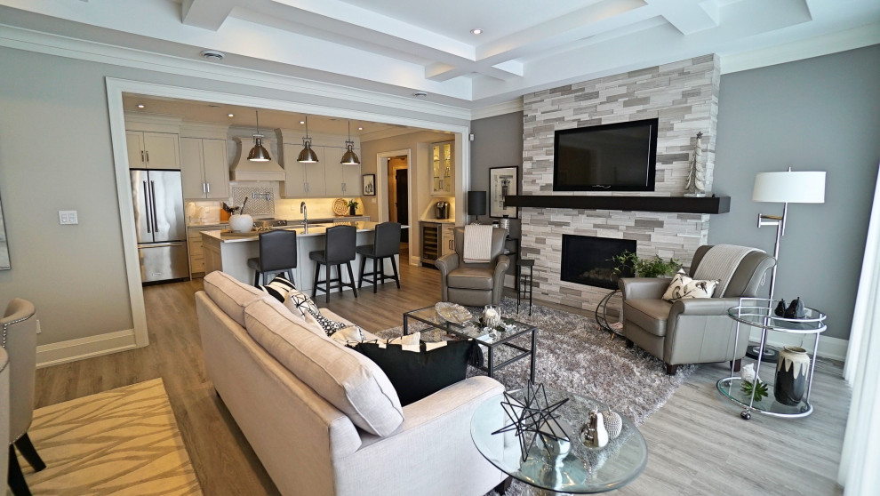 Mittelgroßes, Offenes Modernes Wohnzimmer mit grauer Wandfarbe, Vinylboden, Kamin, Kaminumrandung aus gestapelten Steinen, TV-Wand und grauem Boden in Toronto