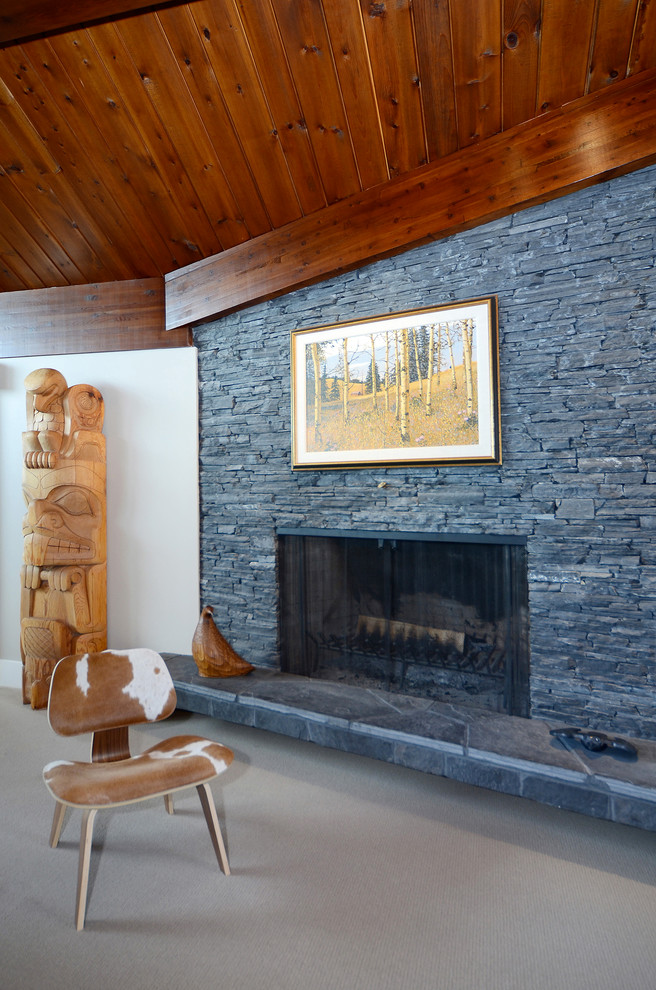 Inspiration pour un salon design avec un mur beige, moquette, une cheminée double-face et un manteau de cheminée en pierre.
