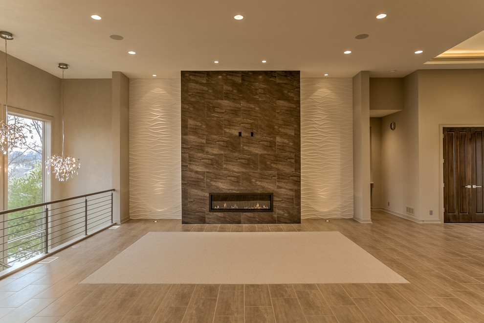 Cette image montre un grand salon design ouvert avec un mur gris, un sol en carrelage de porcelaine, une cheminée ribbon, un manteau de cheminée en carrelage et un téléviseur fixé au mur.