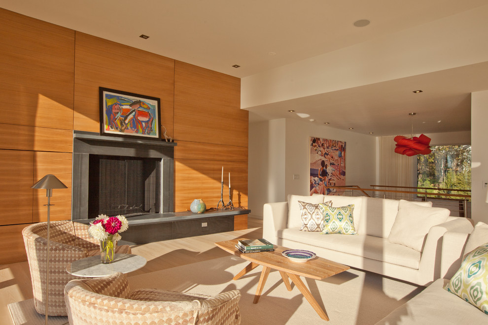 Пример оригинального дизайна: двухуровневая гостиная комната в современном стиле с бежевыми стенами и стандартным камином